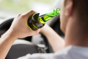 A man drinking in his car and wondering how long it takes for DUI blood samples to come back.