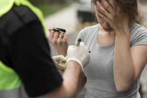 Female driver handing over her keys after a DUI arrest