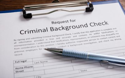 A pen rests on top of a blank criminal background check form.