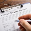 A person fills out a form to authorize a criminal background check.