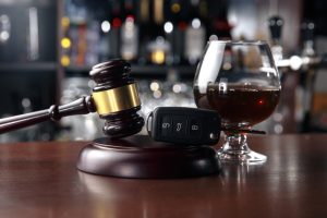 A collection of DUI-related items, like liquor, a gavel, and car keys.