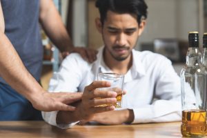 man being stopped from drinking
