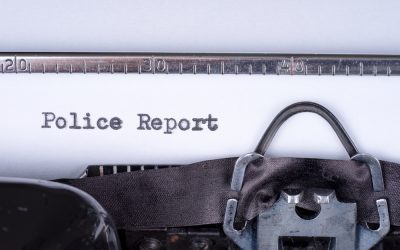 person typing a police report on a typewriter