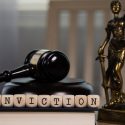 word conviction composed on wooden dice with gavel