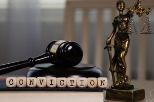 word conviction composed on wooden dice with gavel