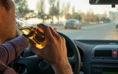 man drinking a beer behind the wheel