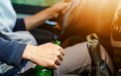 man driving with beer bottle