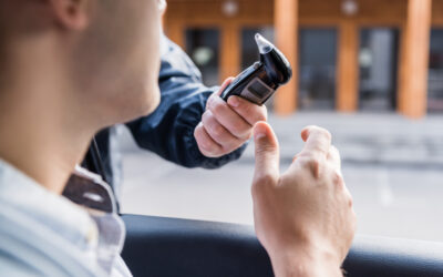 Motorist taking a breathalyzer test during a traffic stop with law enforcement.