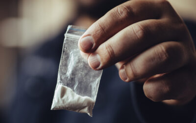 A man holds up cocaine in a bag. How much cocaine is a felony?