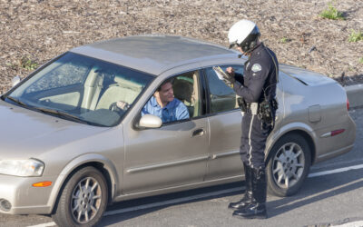 A cop speaks with a driver to determine if they need to arrest them to test for a weed DUI. Weed DUI test samples must be sent to a lab.
