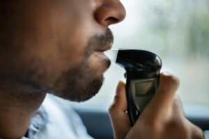 This man taking a breath test could get a DUI even if they are under the limit if their driving is impaired anyway, but it will be harder to convict him.