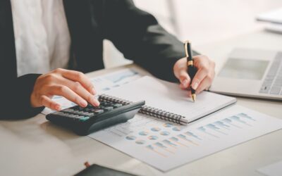 A CPA uses a calculator to fill out a document while wondering if they can have a DUI while being a CPA.