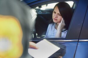 A police officer talks to a woman caught driving without a license in California.
