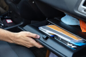 Driver Hand Opening Glovebox Compartment Inside Car searching for their registration after getting a DUI