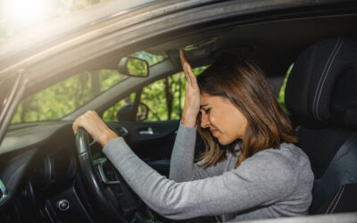 Frustrated woman driving a car wonders, “Does driving without insurance go on your record?”