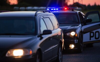 A police car parked behind a car during a traffic stop, leaving the civilian driver to wonder what the Brady List for the police is and how it can impact their DUI case.