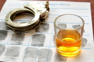 Drink with car keys and handcuffs. Concept for drinking and driving. How long does a misdemeanor DUI stay on your record?