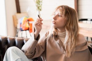 A young woman using marijuana and wondering how long she should wait after smoking weed to drive.