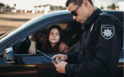 A police officer giving a female driver a ticket. A lawyer can explain what the difference is between a DUI and a wet reckless.
