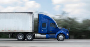 A commercial truck traveling on a highway, with the driver wondering what mistakes they will need to avoid if they have to deal with a commercial DUI charge