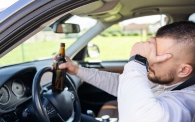 Man drinking alcohol while driving a car and wondering what things to do after a hit and run DUI arrest