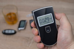 A man uses a breathalyzer and wonders, “What is the legal alcohol limit in the state of California?”