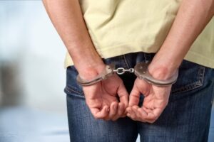 Person’s wrists in handcuffs after a marijuana driving under the influence arrest, with this individual unsure about what will happen in their marijuana DUI case