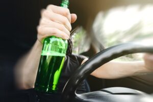 Bottle of alcohol in a driver’s hand, leading them to wonder about the defenses against a commercial DUI charge.