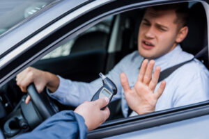 A man declining a breathalyzer test from a police officer. Learn about 5 mistakes to avoid in a DUI refusal case.