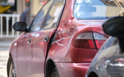 Dented car with damaged body parked on the city street side. 5 ways a lawyer can help with a hit and run DUI case.