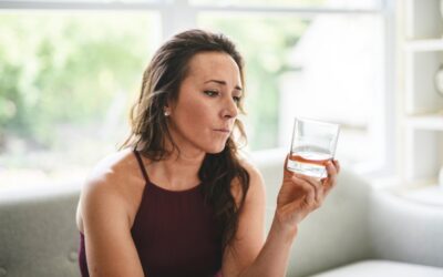 A woman with a tumbler of whiskey as she wonders what happens if she gets caught drinking on DUI probation