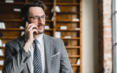 A lawyer listens to a client on the phone asking, “What are the possible DUI charges?” 