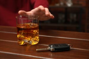 A glass of alcohol by keys. A lawyer can tell you what constitutes drunk driving in California. 