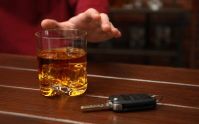 A glass of alcohol by keys. A lawyer can tell you what constitutes drunk driving in California. 