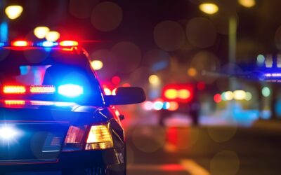 A police car with its light on at night because an officer believes they have probable cause to stop someone.