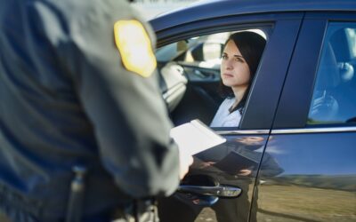 woman in a car with a law enforcement officer for an article that explains whether someone will go to jail for DUI child endangerment.