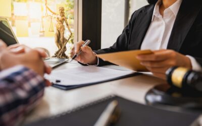 Lawyer and client giving over paperwork together at a desk, with the client wondering what a notice of suspension is in a California DUI case.